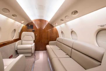 Gulfstream charter jet interior with three passenger sofa and seats